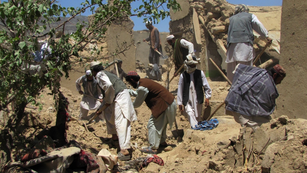 Afghan villagers search for dead bodies of people who were killed in a NATO airstrike on a home in Sajawand village in Logar province, south of Kabul on June 6, 2012. At least 15 civilians, including