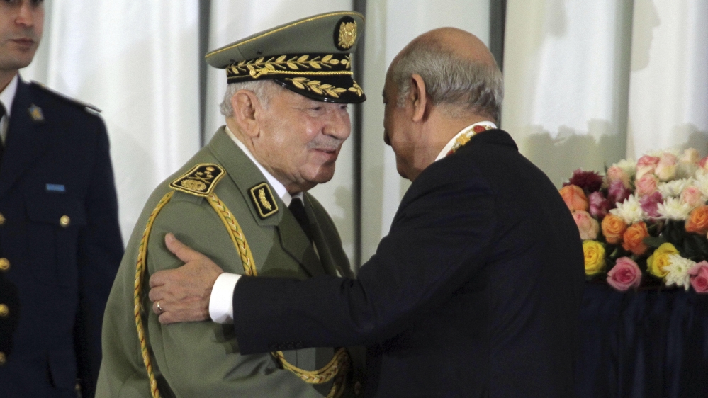 In this photo taken Thursday, Dec. 19, 2019, Algerian military chief Gaid Salah, left, embraces president Abdelmajid Tebboune during an inauguration ceremony in the presidential palace, in Algiers, Al
