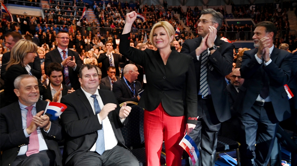 CROATIA-POLITICS-ELECTION Croatian President Kolinda Grabar Kitarovic (C) accompanied by her husband Jakova Kitarovic (2nd-L) and Croatian Prime Minister Andrej Plenkovic (2nd-R) gestures