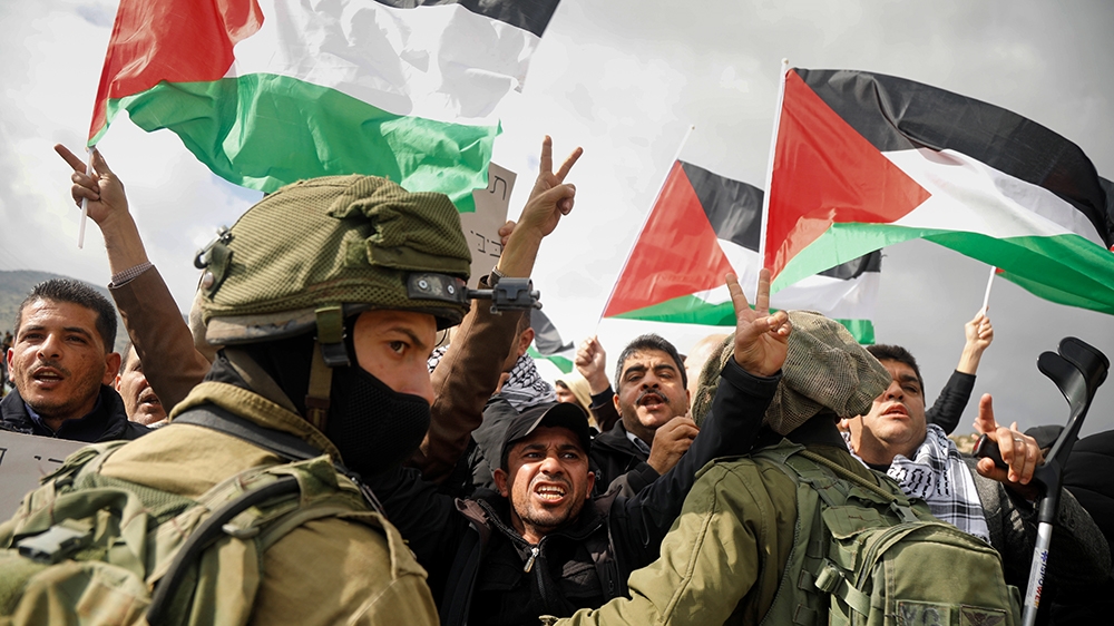Palestinian demonstrators gesture in front of Israeli forces during a protest against the U.S. president Donald TrumpO~s Middle East peace plan, in Jordan Valley in the Israeli-occupied West Bank Janu