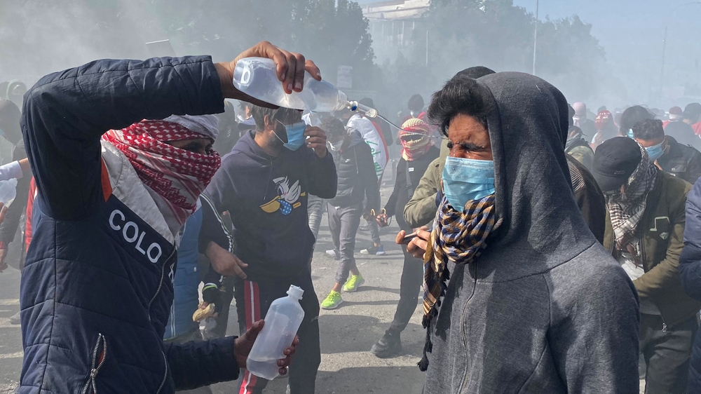 A man pours medical fluid on the face of a demonstrator who was affected by tear gas during ongoing anti-government protests in Nassiriya, Iraq January 26, 2020. REUTERS/Ahmed Dhahi