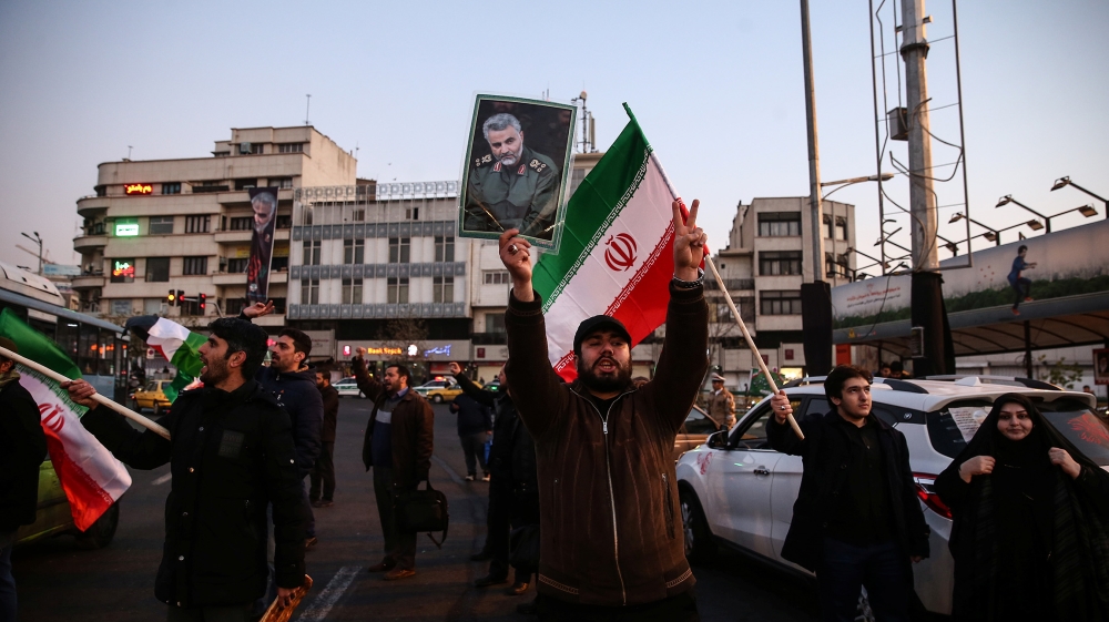 A man holds a picture of late Iranian Major-General Qassem Soleimani, as people celebrate in the street after Iran launched missiles at U.S.-led forces in Iraq, in Tehran, Iran January 8, 2020. Nazani