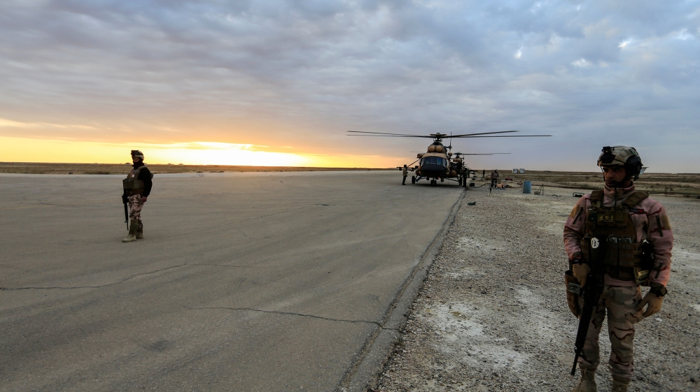 Iraqi security forces are seen at Ain al-Asad airbase near a military helicopter in Anbar province, Iraq December 29, 2019. REUTERS/Thaier Al-Sudani