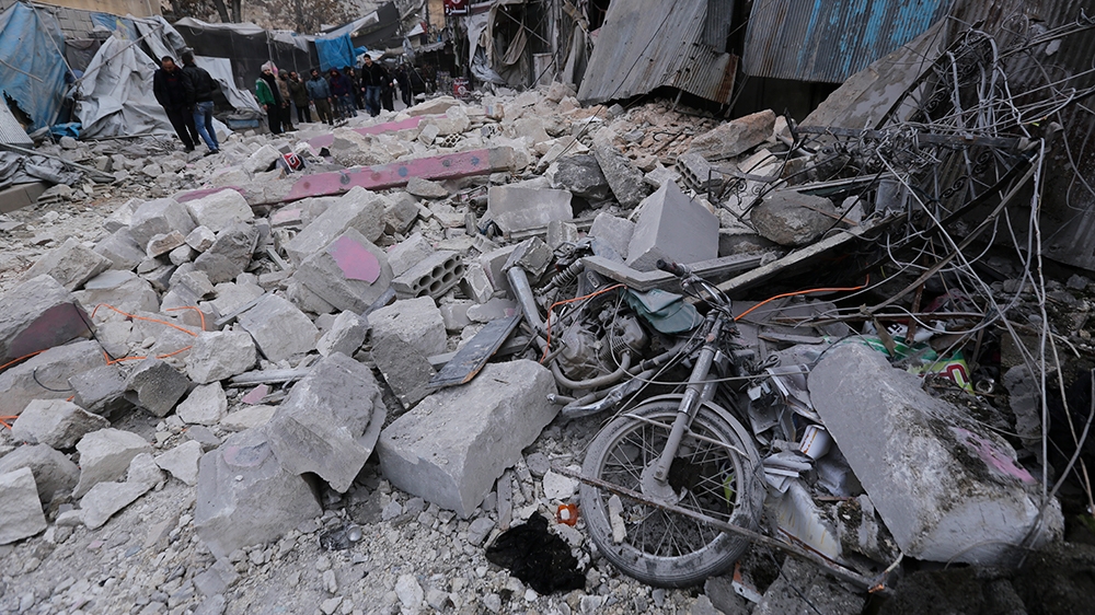 People look at destruction by the government airstrikes in the town of Ariha, in Idlib province, Syria, Wednesday, Jan. 15, 2020. Syrian government warplanes struck a market and an industrial area Wed
