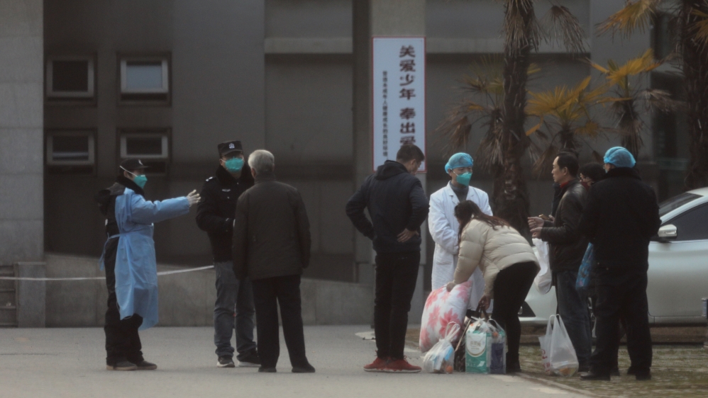 Medical staff and security personnel stop patients' family members from being too close to the Jinyintan hospital, where the patients with pneumonia caused by the new strain of coronavirus 