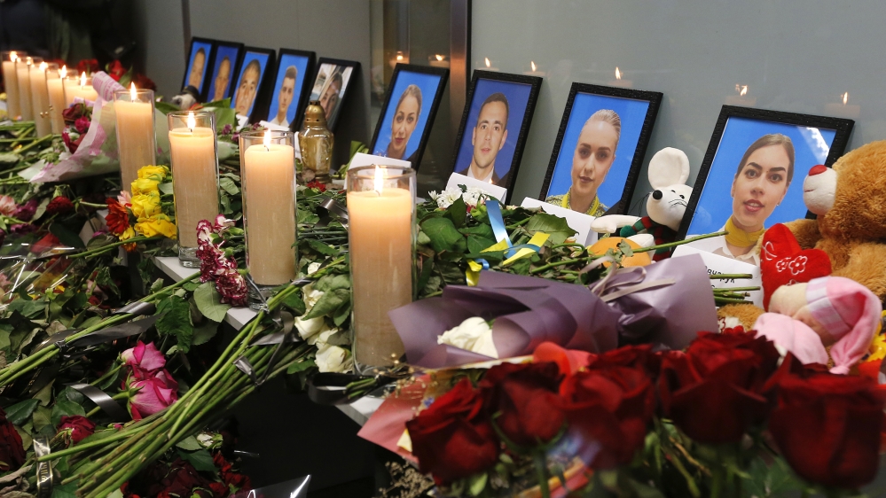 Flowers and candles are placed in front of portraits of the flight crew members of the Ukrainian 737-800 plane that crashed on the outskirts of Tehran, at a memorial inside Borispil international airp