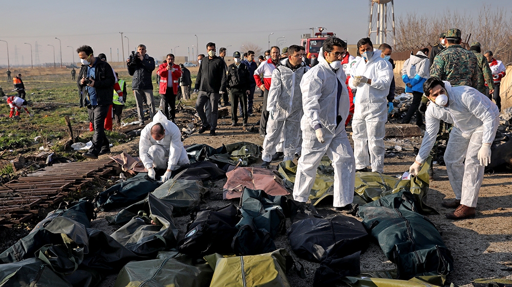 Forensic investigators work at the scene of a Ukrainian plane crash as bodies of victims are collected, in Shahedshahr, southwest of the capital Tehran, Iran, Wednesday, Jan. 8, 2020. A Ukrainian airp