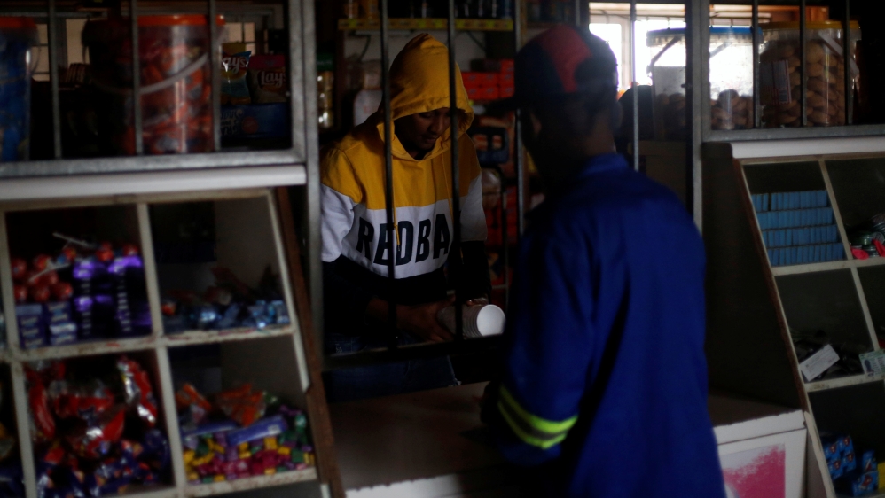 Shopkeeper serves a customer during an electricity load-shedding blackout in Hillcrest