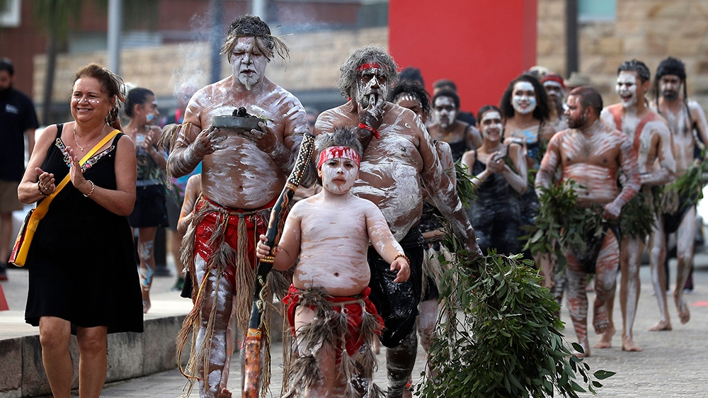 boriginal people carry a small fire at the beginning of the Wugulora Indigenous Morning Ceremony as part of Australia Day celebrations in Sydney, Australia, Sunday, Jan. 26, 2020. (AP Photo/Rick Rycro