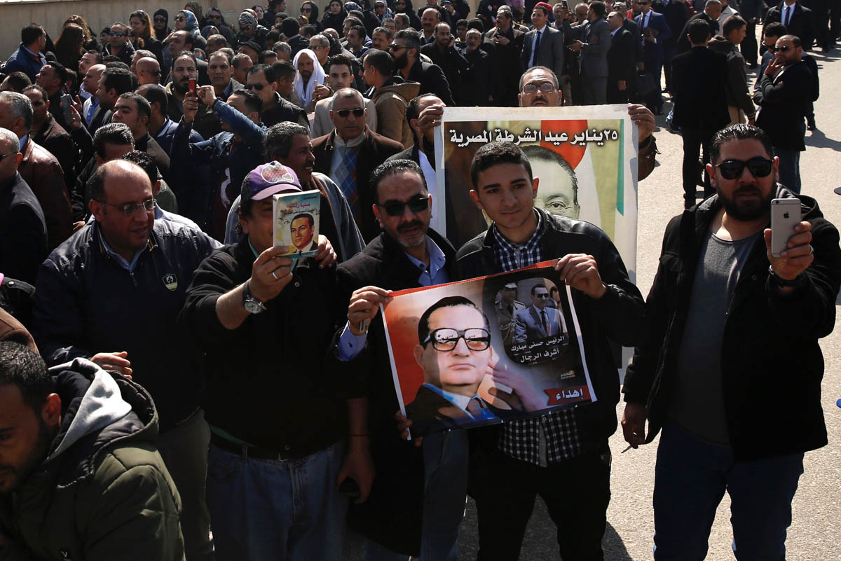 epa08248556 People hold photos of late former Egyptian President Hosni Mubarak as they gather outside Mosheer Tantawy mosque ahead of Mubarak''s funeral, in Cairo, Egypt, 26 February 2020. Mubarak died