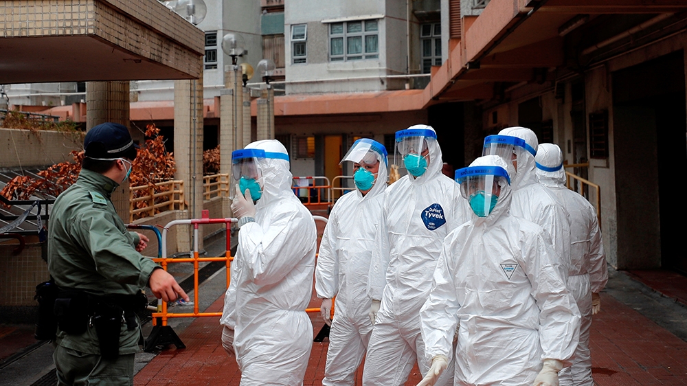 Police in protective gear wait to evacuate residents from a public housing building, following the outbreak of the novel coronavirus, in Hong Kong, China February 11, 2020. REUTERS/Tyrone Siu