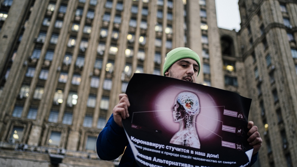 An environmental activist pickets in front of the Russian Foreign Ministry headquarters demanding a thorough screening of passengers arriving from Southeast Asia to protect against