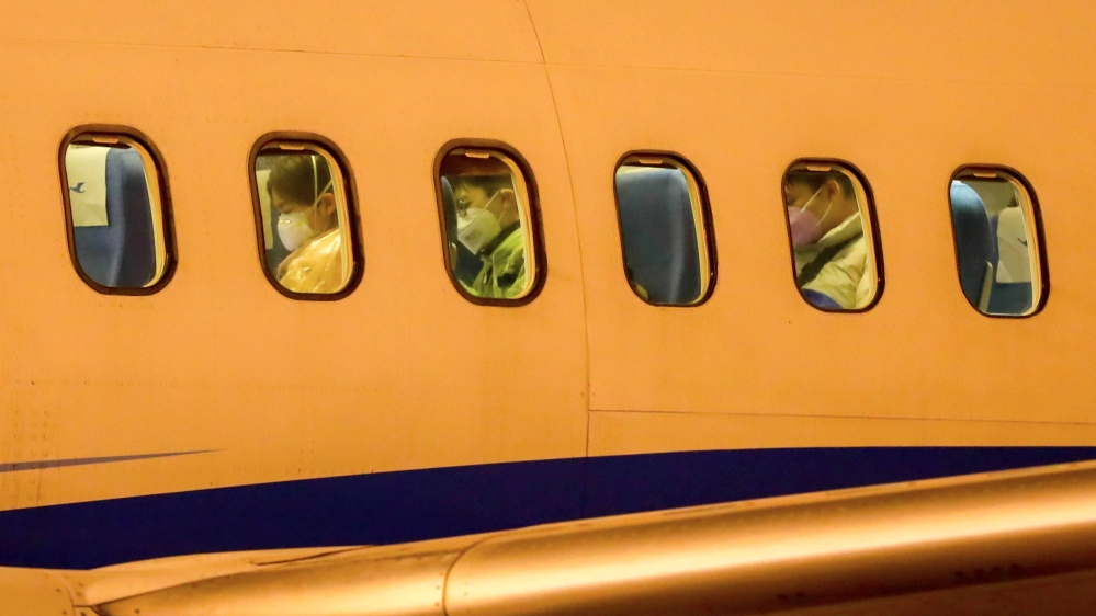 Passengers wearing face masks are seen on a Xiamen Airlines airplane before getting off the charter flight sent by the Chinese government to bring home Hubei residents from Thailand's Bangkok, at Wuha