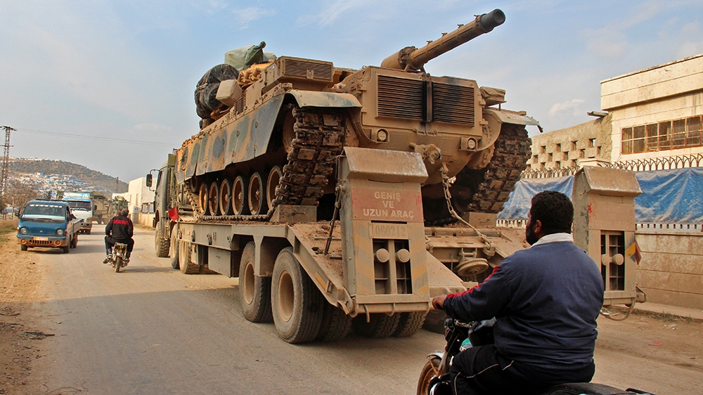 A Turkish military truck drives through the village of Qah in Syria's Idlib province heading towards the western countryside of Aleppo province on February 19, 2020. (Photo by Ahmad al-ATRASH / AFP)