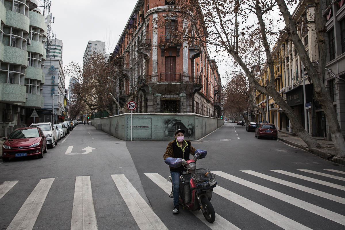 WUHAN, CHINA - FEBRUARY 08: (CHINA OUT) A man by bicycles past an empty street on February 8, 2020 in Wuhan, Hubei province, China. The number of those who have died from the Wuhan coronavirus, known