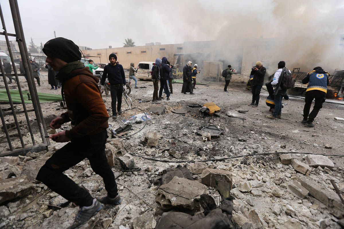 People gather after a government airstrike in the city of Idlib, Syria, Tuesday, Feb. 11, 2020. The latest violence in Idlib came as government forces came closer to capturing the last rebel-held part