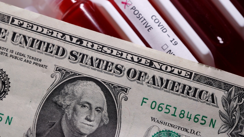 Dollar banknote is placed on the test tubes with fake blood labelled with the coronavirus disease (COVID-19) in this illustration