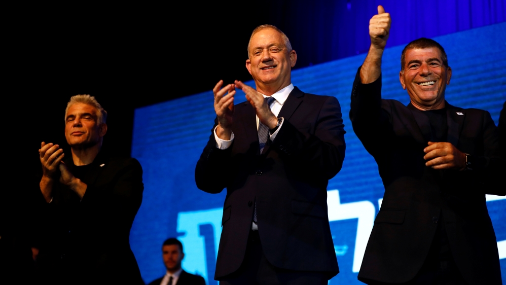 Blue and White party leader Benny Gantz stands next to party co-leaders Yair Lapid and Gaby Ashkenazi after speaking to supporters following the announcement of exit polls in Israel''s election at the