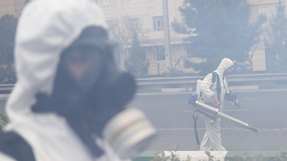 Members of firefighters wear protective face masks, amid fear of coronavirus disease (COVID-19), as they disinfect the streets, ahead of the Iranian New Year Nowruz, March 20, in Tehran