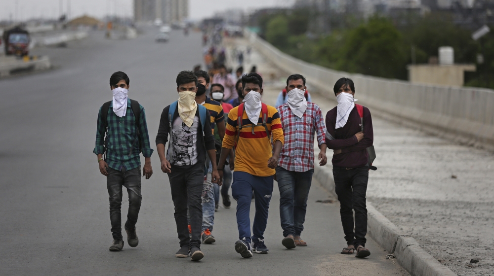 A group of Indian daily wage laborers walk along an expressway hoping to reach their homes, hundreds of kilometers away, as the city comes under lockdown in Ghaziabad, on the outskirts of New Delhi, I