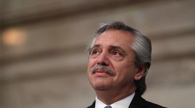 A retired man feeds pigeons at a public park in Buenos Aires
