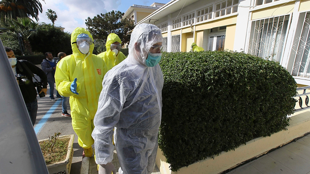 Medics walk outside a clinic where the flight crew as well as several people who were in contact with an Italian man who tested positive for COVID-19 went in for tests, in Algeria, Wednesday, Feb. 26,