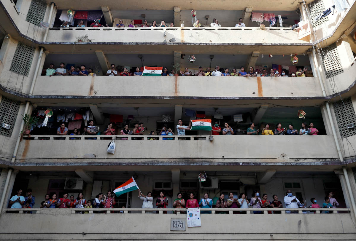 People clap and bang utensils from their balconies to cheer for emergency personnel and sanitation workers who are on the frontlines in the fight against coronavirus, in Mumbai, India, March 22, 2020.