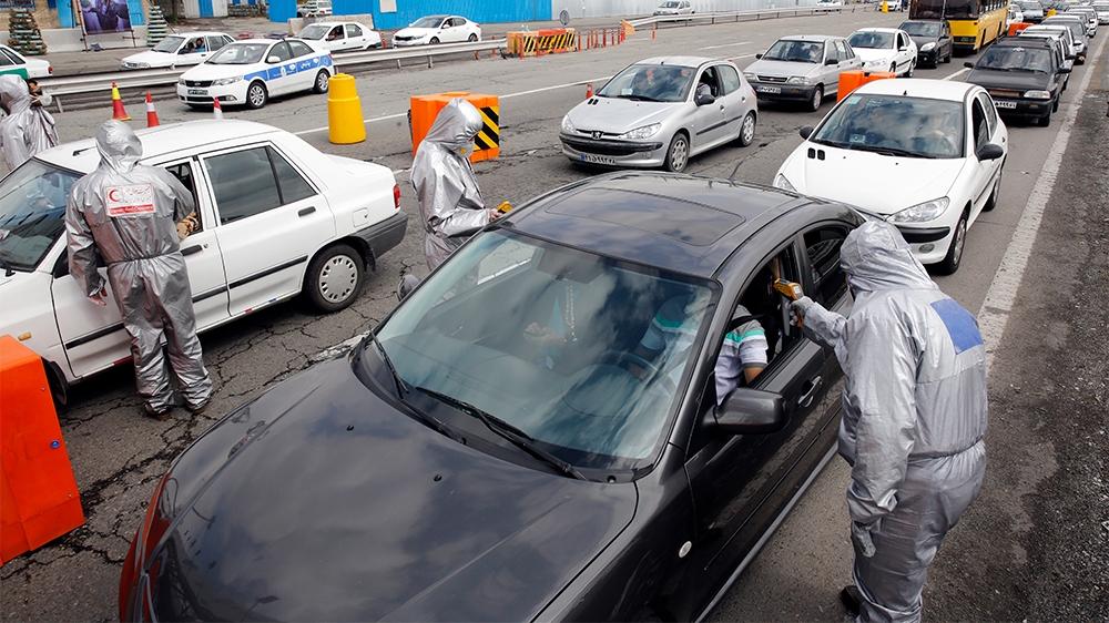 epaselect epa08323825 Members of Iranian red crescent test people with possible coronavirus Covid-19 symptoms, as police blocked Tehran to Alborz highway to check every car following ordered by Irania