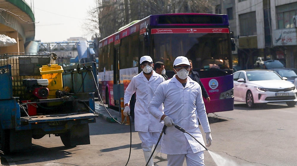 Members of the medical team wear protective face masks, following the coronavirus outbreak, as they spray disinfectant liquid to sanitise streets in Tehran, Iran March 05, 2020. WANA (West Asia News A