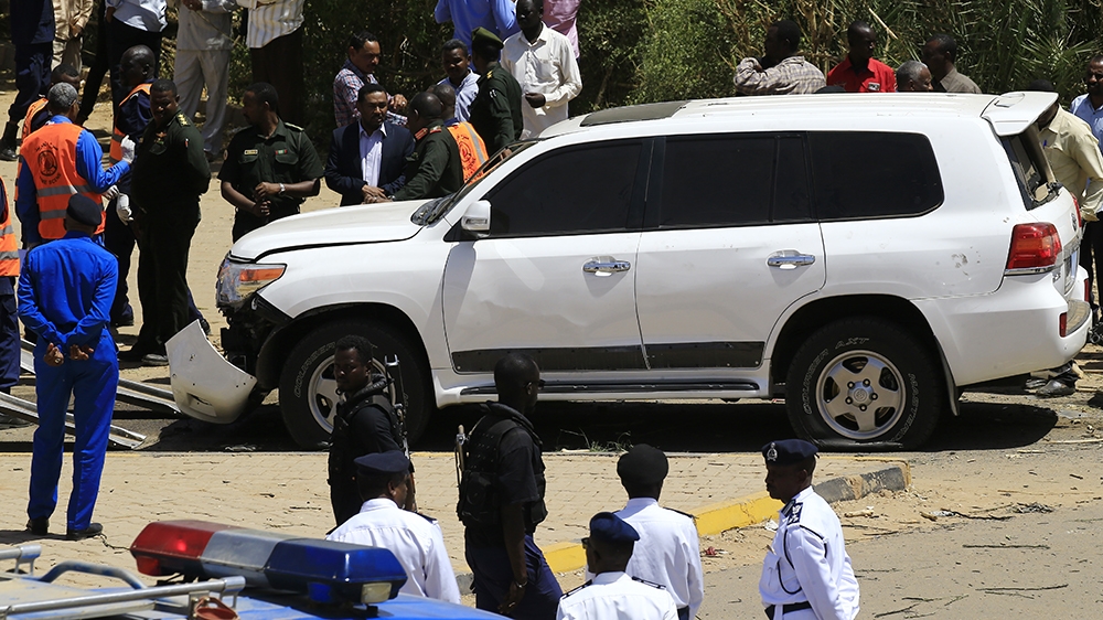 Sudanese rescue teams and security forces gather next to a damaged vehicle at the site of an assassination attempt against Sudan''s Prime Minister Abdalla Hamdok, who survived the attack with explosive