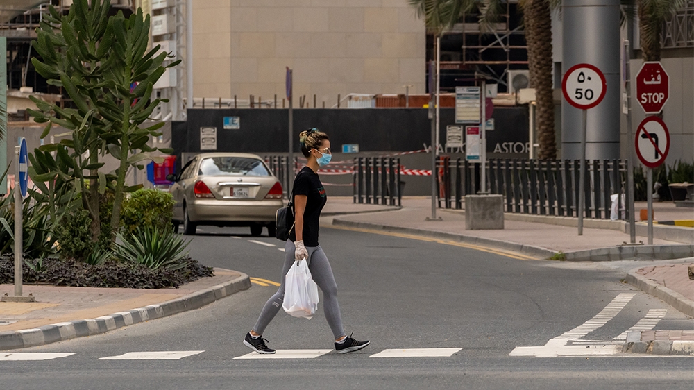 A woman wearing protective mask walks in West Bay area in Doha, Qatar, March 25, 2020. Qatar has imposed a series of measures to contain the coronavirus outbreak, including closing of parks and public