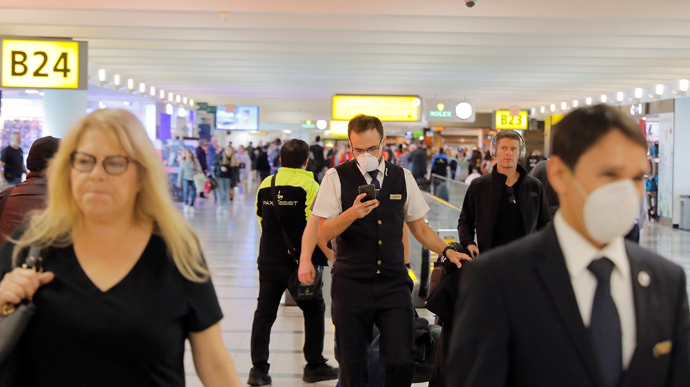 Travelers wear masks in John F Kennedy International Airport in New York, U.S., amid coronavirus reports, March 11, 2020. REUTERS/Lucas Jackson