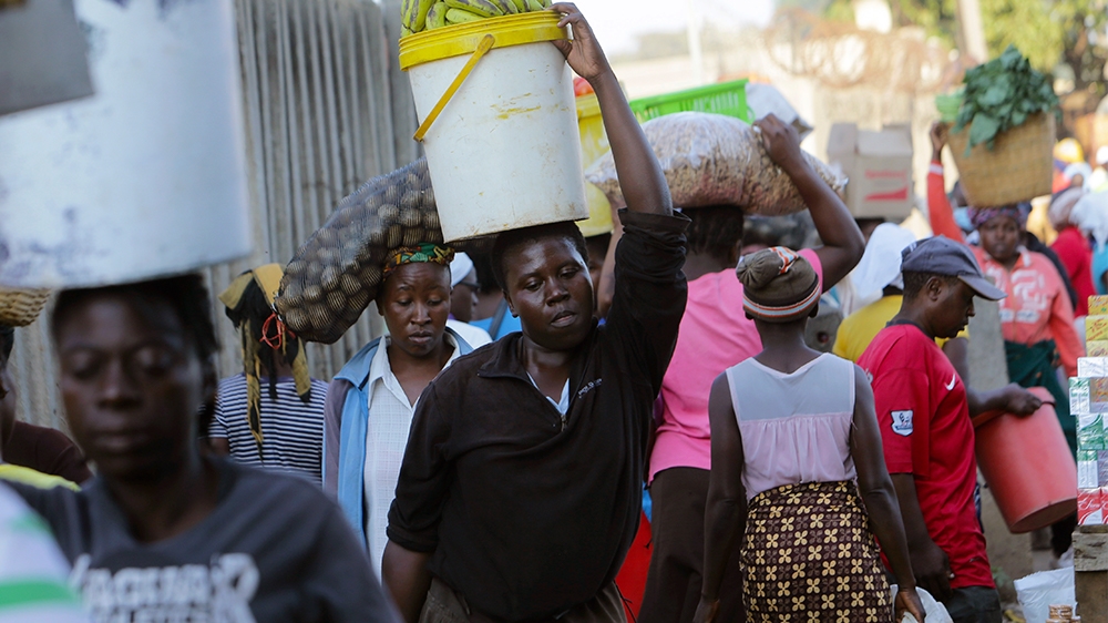 Women carry various foodstuffs at a local market in Harare, Zimbabwe, Friday,March, 27, 2020.Zimbabwes public hospital doctors are on strike over what they called a lack of adequate protective gear