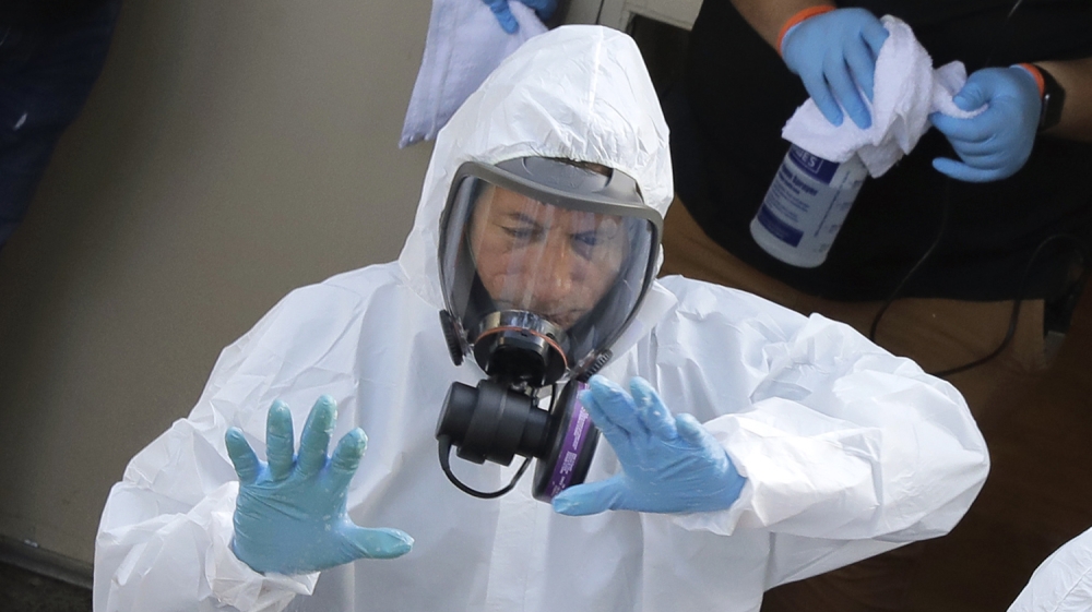 Servpro cleaning workers are sprayed as they exit the Life Care Center in Kirkland, Wash., Thursday, March 12, 2020, at the end of a day spent cleaning inside the facility near Seattle. The nursing ho