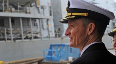 Captain Brett E. Crozier watches Royal Navy HMS Sutherland as she arrives in Yokosuka