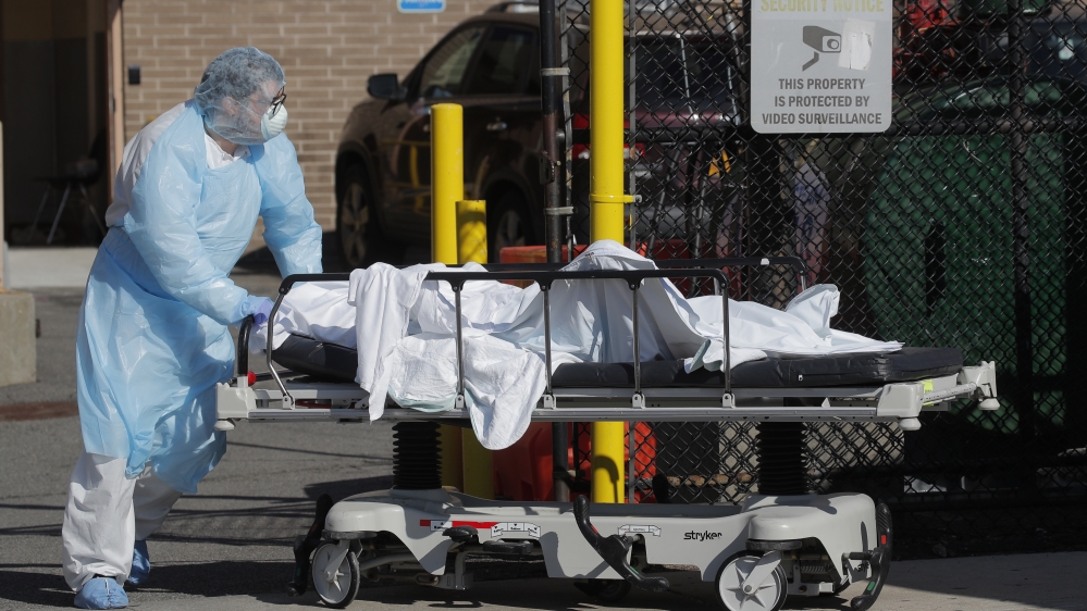 Healthcare worker wheels body of deceased person from Wyckoff Heights Medical Center during outbreak of coronavirus disease (COVID-19) in New York