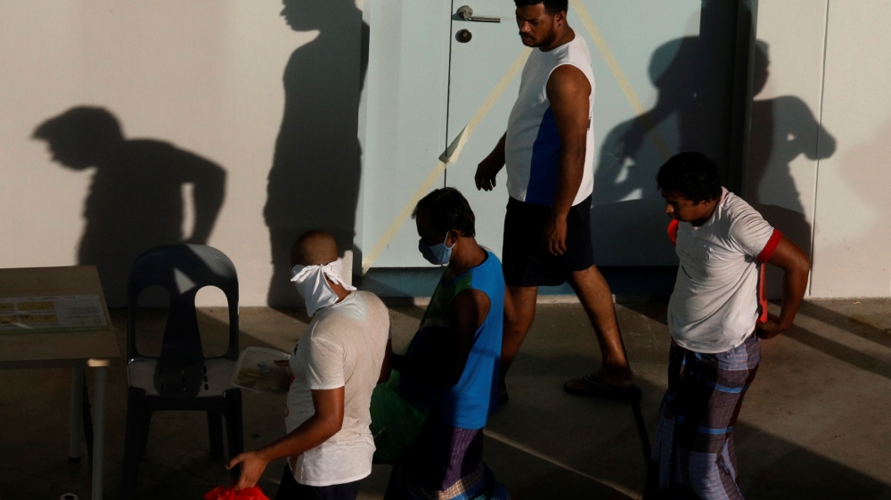 Migrant workers collect their breakfast at a dormitory declared as an isolation area, during the coronavirus outbreak (COVID-19) in Singapore