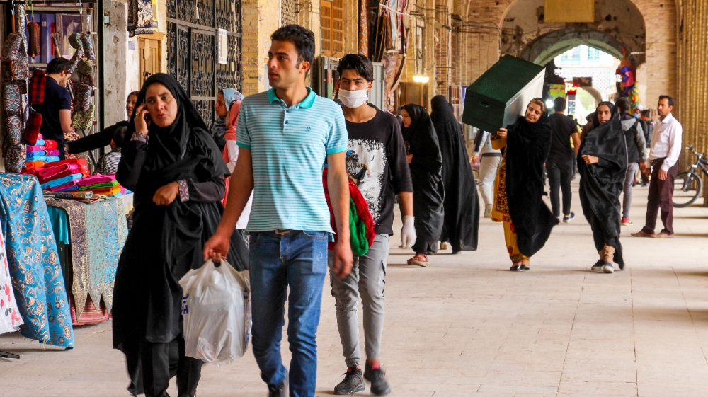 RAN-HEALTH-VIRUS Iranians, some wearing personal protective equipment, walk past shops in the southeastern city of Kerman on April 11, 2020, amid the coronavirus (COVID-19) pandemic.