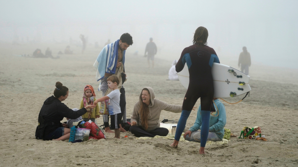 People sit together at Huntington City Beach during the outbreak of the coronavirus disease (COVID-19) in Huntington Beach, California, U.S., April 25, 2020. REUTERS/Kyle Grillot