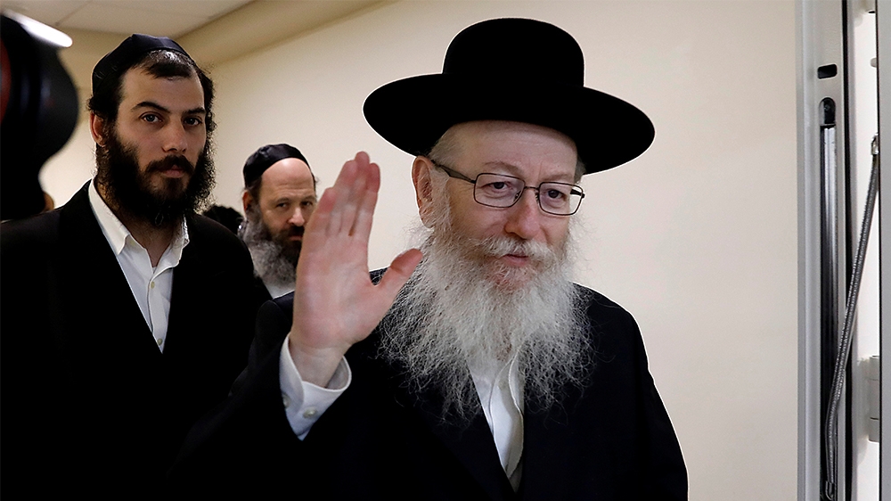 Israeli Health Minister Yakov Litzman, a rabbi from the United Torah Judaism party, waves to journalists after handing in his resignation to Prime Minister Benjamin Netanyahu, during the weekly cabine