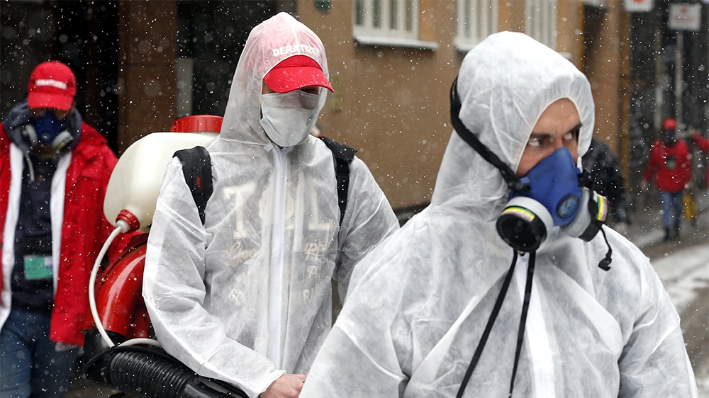epa08318157 Employees of the local cleaning company 'Deratizer' wearing face masks with filters disinfect a building in Sarajevo, Bosnia and Herzegovina, 24 March 2020. Several European countries hav