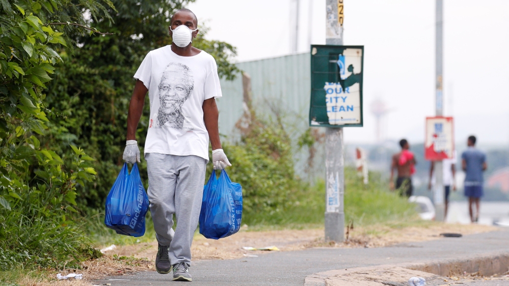 A man carries home groceries during a nationwide 21 day lockdown in an attempt to contain the coronavirus disease (COVID-19) outbreak in Umlazi township near Durban