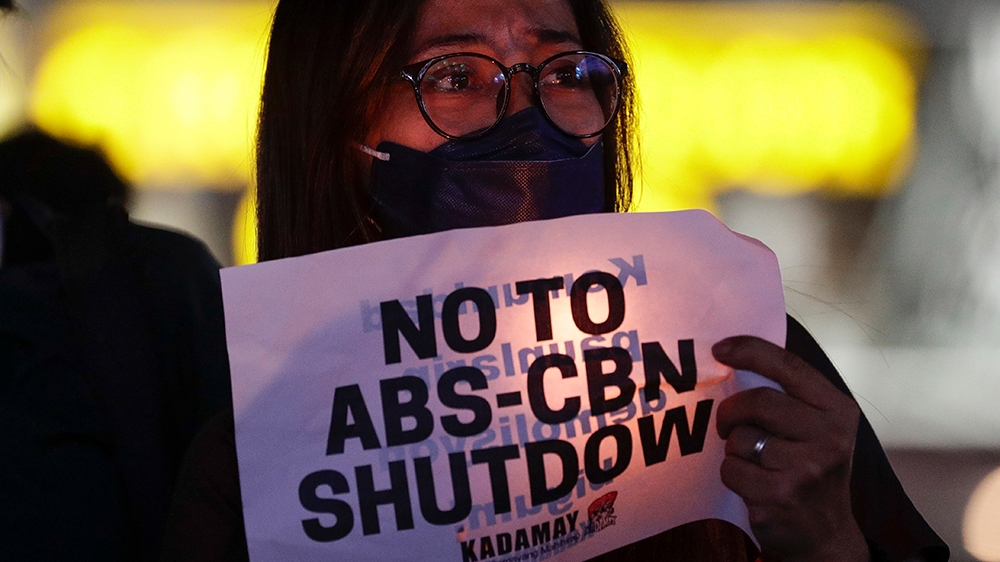 A protester holds a slogan during a rally in metropolitan Manila, Philippines on Monday, Feb. 10, 2020. The Philippine government’s chief lawyer asked the Supreme Court on Monday to shut down the coun