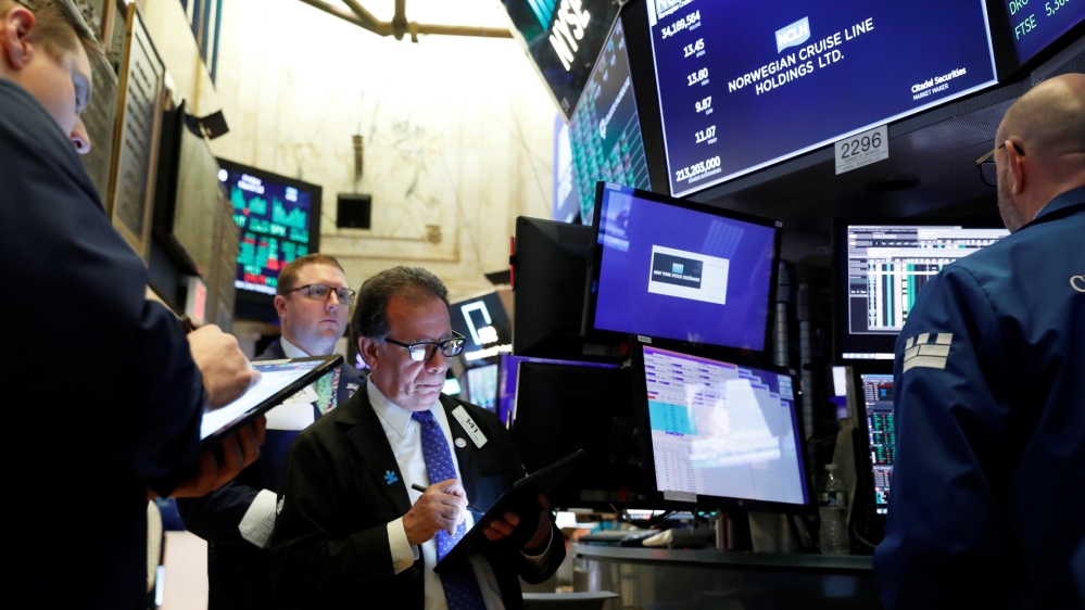Traders wait for stocks to resume trading on Norwegian Cruise Lines Holding Ltd. on the floor of the New York Stock Exchange in New York