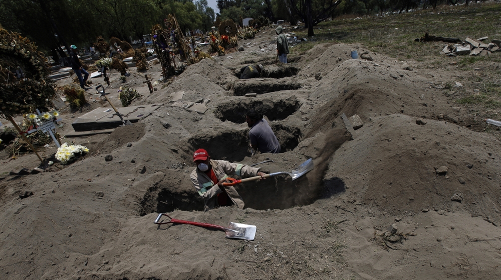 Melvin Sanaurio, front, digs a grave at the San Lorenzo Tezonco Iztapalapa cemetery in Mexico City, Tuesday, June 2, 2020, amid the new coronavirus pandemic. 
