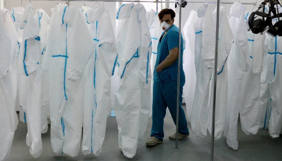 A medical specialist walks past personal protective equipment in a hospital in Moscow