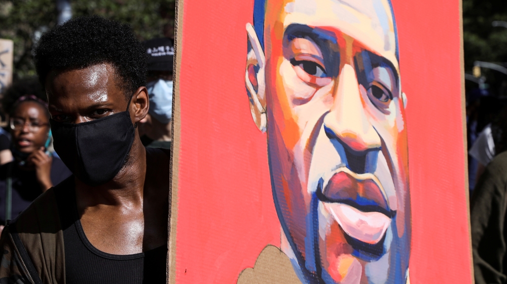 A demonstrator holds a placard depicting George Floyd during a protest against the death in Minneapolis police custody of George Floyd, in Brooklyn, New York City, U.S., June 3, 2020. REUTERS/Caitlin