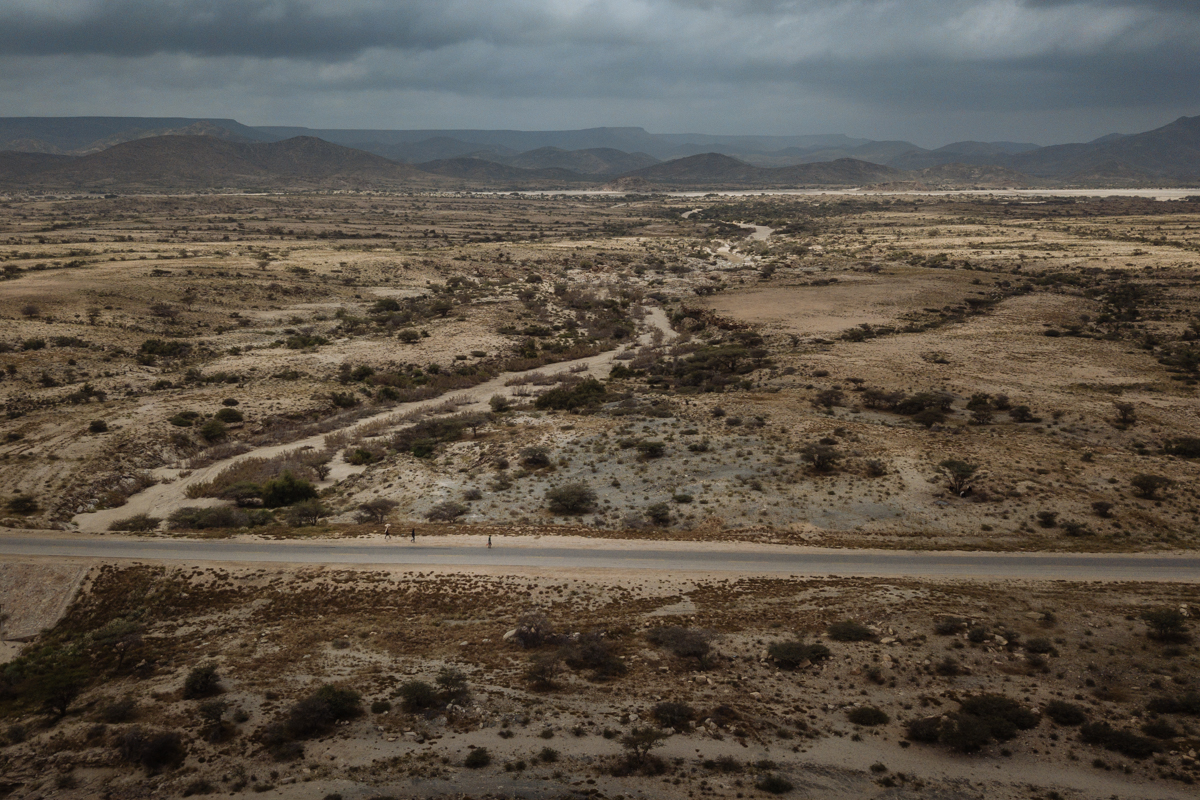 Migrants walking along the side of the road in the desert near Burco, Somaliland.