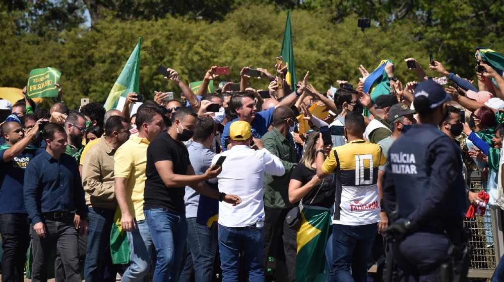 Brazil''s President Jair Bolsonaro greets supporters gathered outside the presidential palace in Brasilia, Brazil, Sunday, May 31, 2020. (AP Photo/Andre Borges)