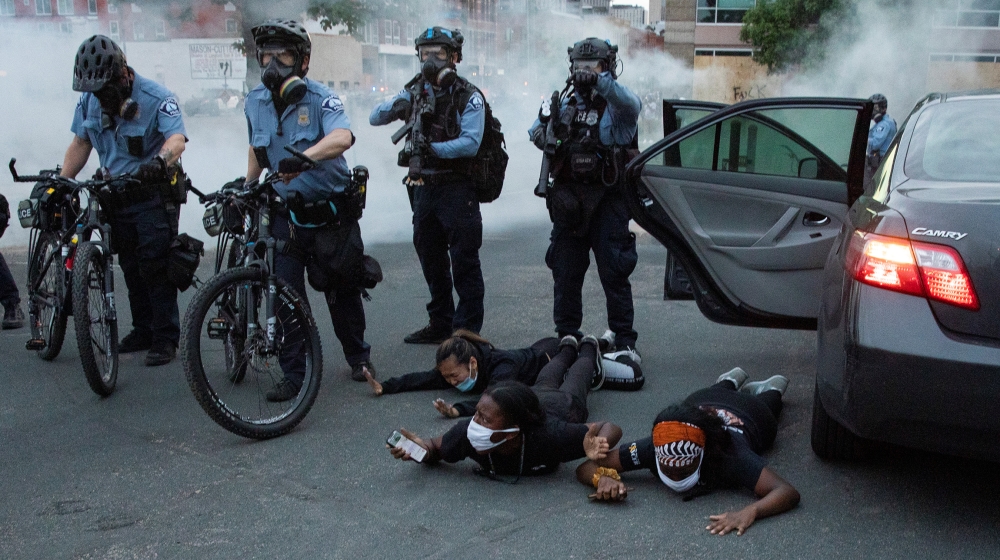 Minneapolis Police Department officers detain a group outside of a car during continued demonstrations in reaction to the death in Minneapolis police custody of George Floyd, in Minneapolis, Minnesota